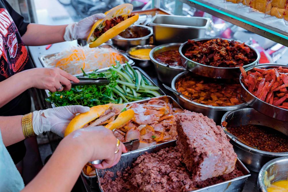 Vendeuse met différentes garnitures dans un Banh Mi vietnamien
