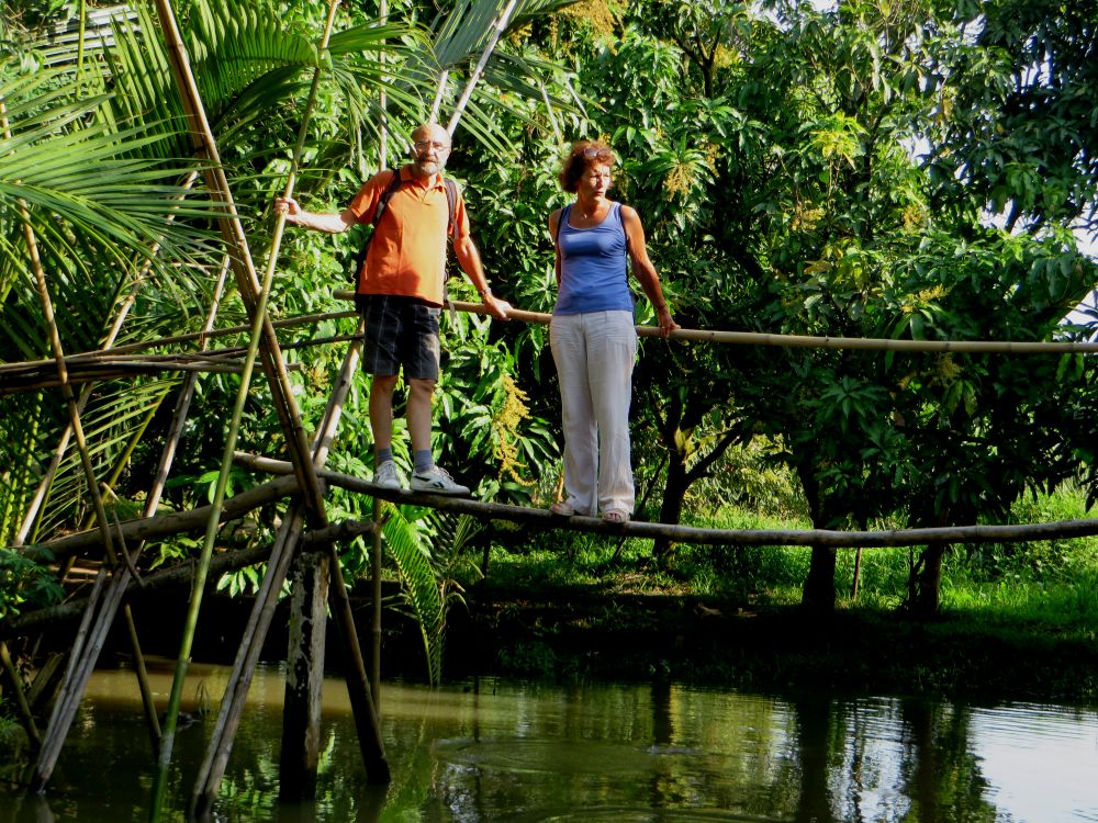 ben tre, mekong delta, vietnam, couple de voyageurs sur un pont de bambou, nature verdoyante