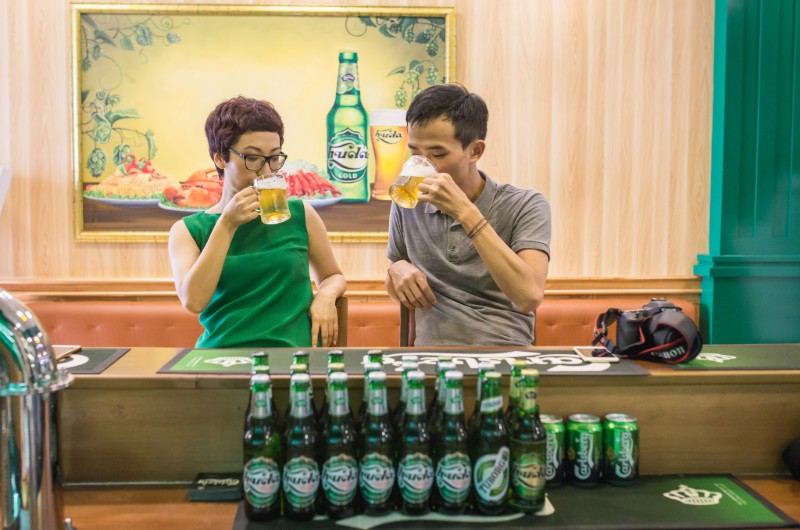 un couple buvant de la bière Huda de la ville de Hue au Vietnam