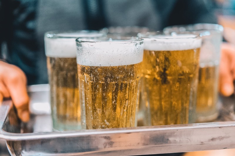 un plateau avec des verres de bière blonde avec de la mousse blanche au Vietnam