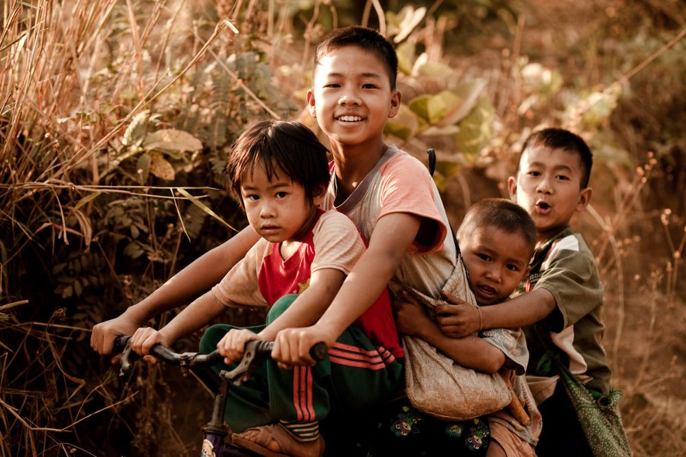 enfants thailandais à vélo rirent