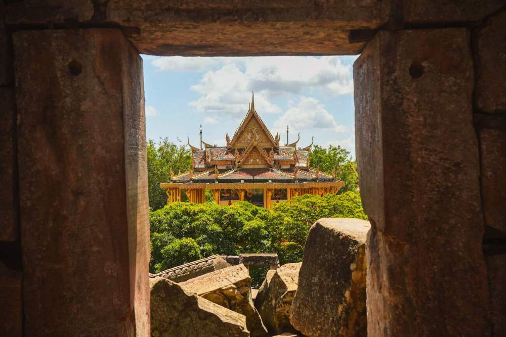 vue de la porte d'un temple en ruine sur un temple modern somptueux à Battambang, au Cambodge