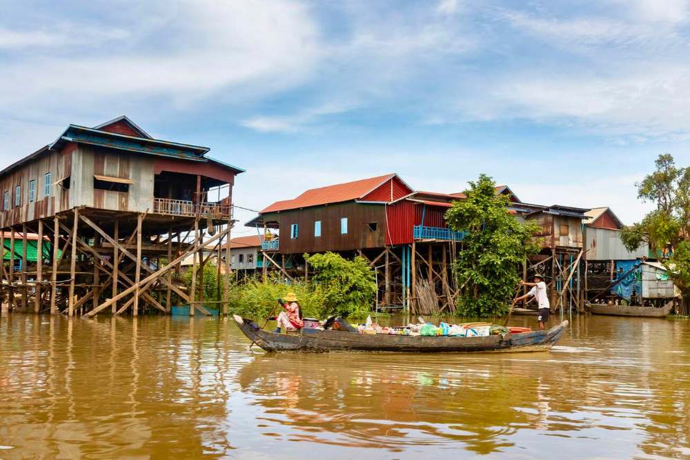 pirogue devant les maisons sur pilotis dans un village flottant sur le lac Tonle Sap, Cambodge en septembre
