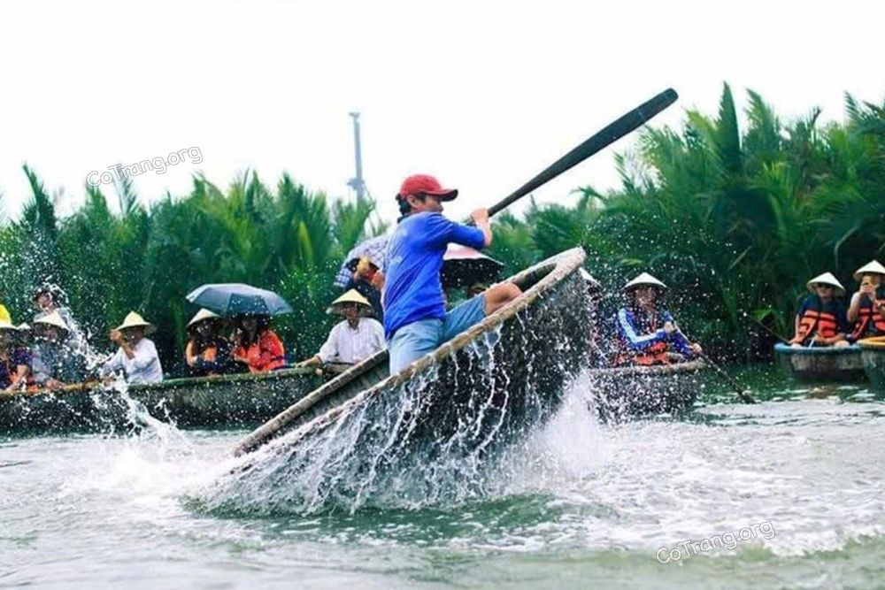 Un batelier exécute une danse de bateau-panier dans la forêt de cocotiers de Cam Thanh, à Hoi An.