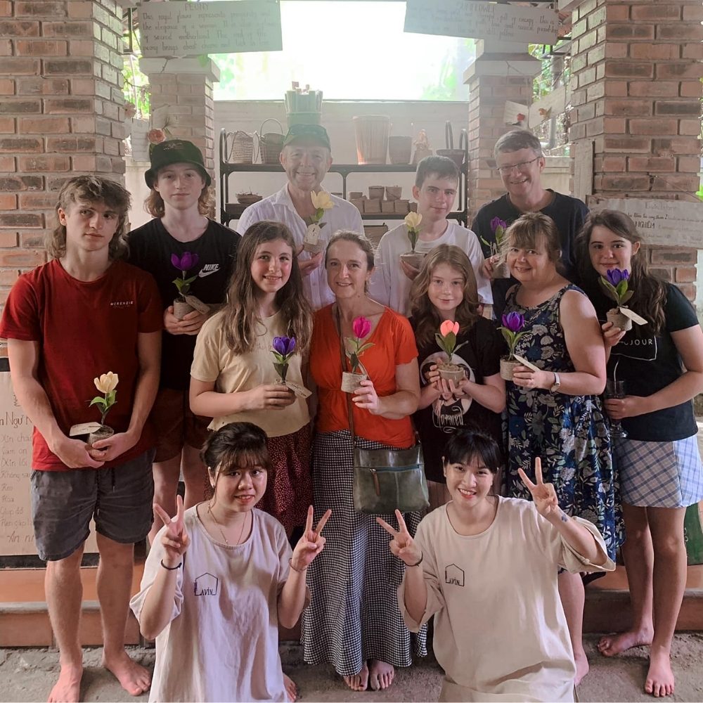 Les touristes prennent des photos souvenirs avec leurs fleurs en papier faites maison chez Lavin à Hue