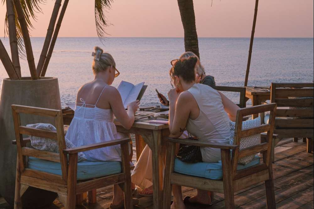 Un groupe de touristes profite d'un dîner au coucher du soleil sur la plage du Mango Bay Resort à Phu Quoc.