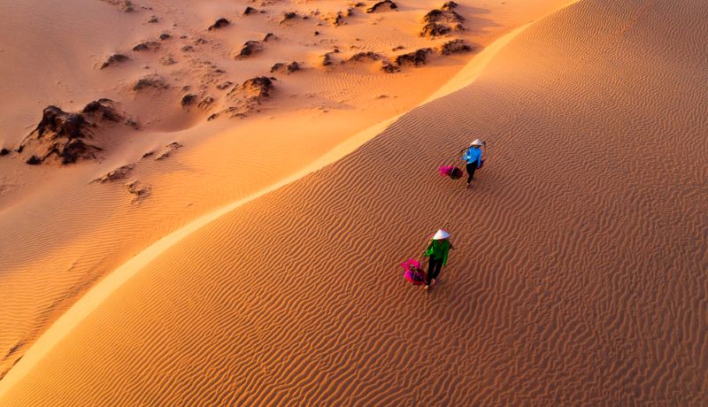 deux femmes marchant sur les dunes de sable à Mui Ne Vietnam