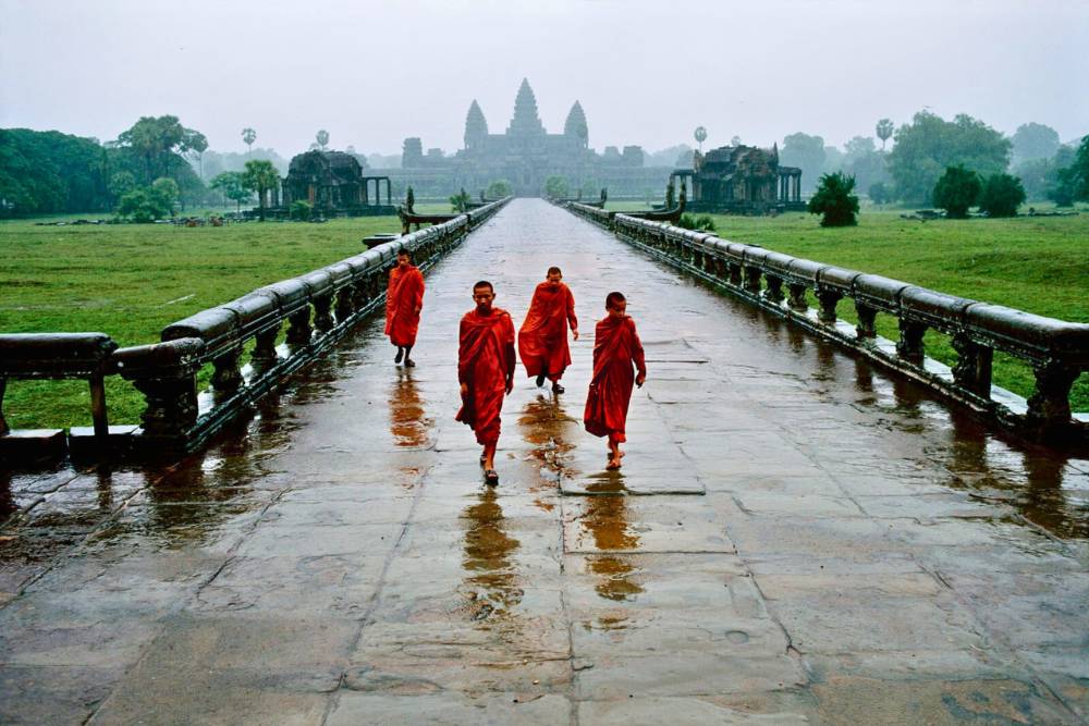 les moines marchent à Angkor Wat après la pluie