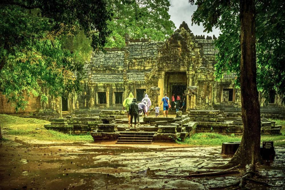 les voyageurs visitent un temple d'Angkor sous la pluies
