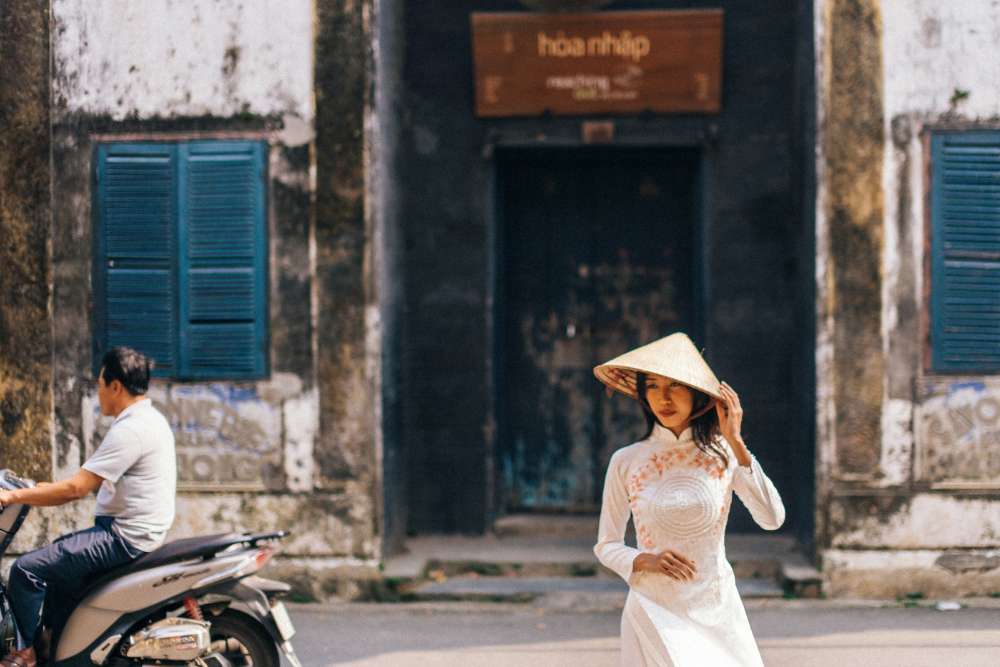 un femme vietnamienne en Ao Dai et chapeau conique