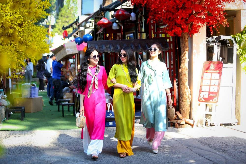 les jeunes filles vietnamiens sortent dans la rue dans leur tenue traditionnelle Ao Dai lors du Têt