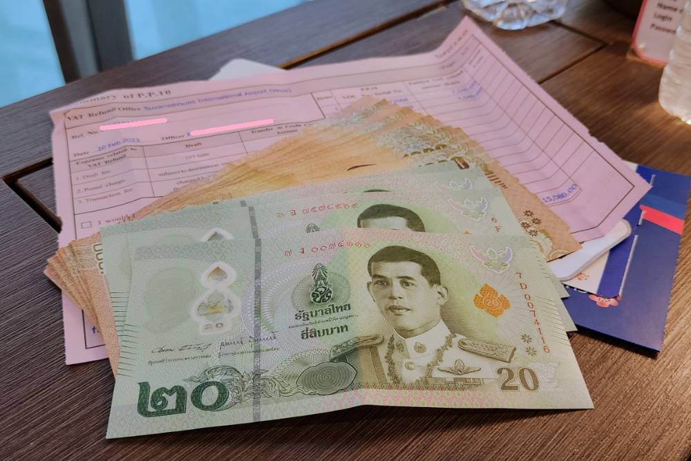 une facture et quelques billets de baht thailandais
