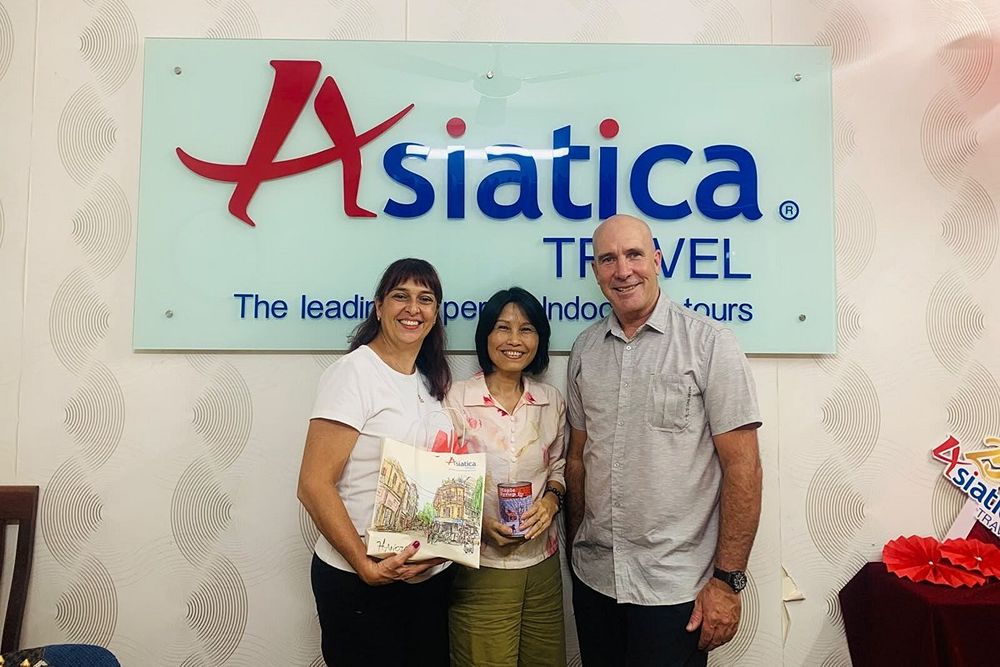 Le couple pose pour une photo souvenir devant l'agence de voyages Asiatica.